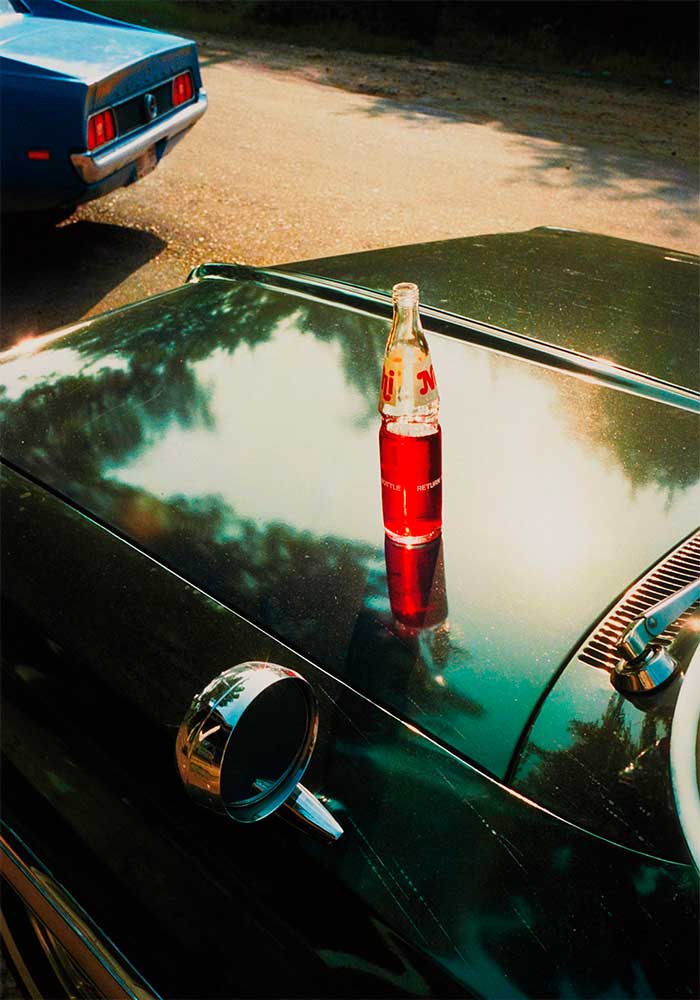 William Eggleston foto sin título de 1974. Refresco en capot de auto.